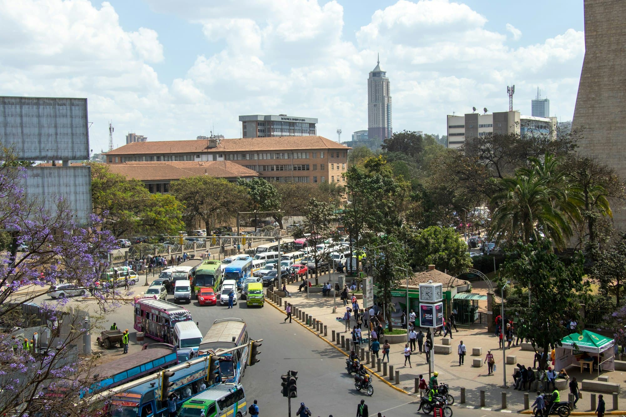 Matatus and traffic on a tree-lined street in central Nairobi