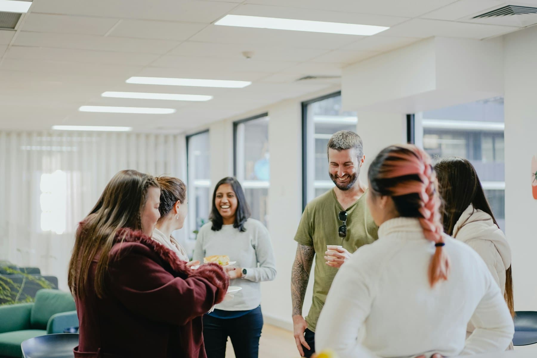 Colleagues chatting in a bright open-plan office kitchen