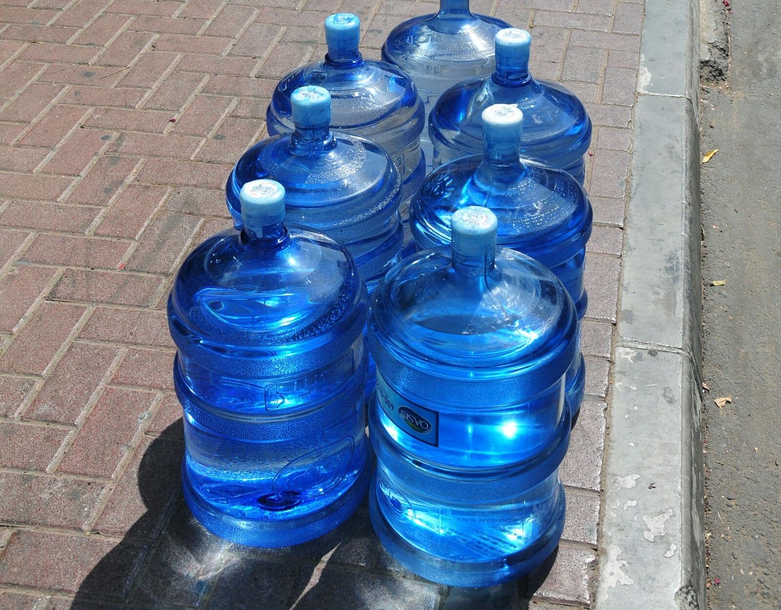 Filled blue 20 litre water bottles grouped together